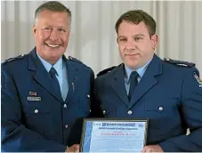  ?? ROBERT STEVEN/STUFF ?? Bay of Plenty police Superinten­dent Andy McGregor presents the award to Constable Ben Jones.