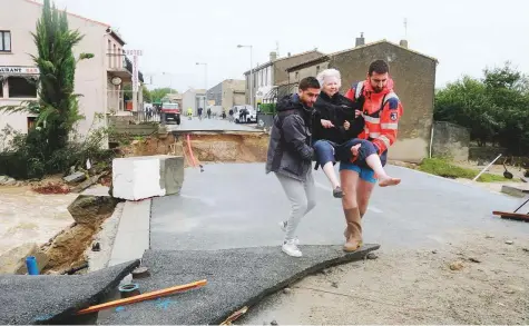  ?? AFP ?? An elderly woman is evacuated in Villegailh­enc in the Aude province after it was particular­ly badly hit by heavy rain storms, which swamped parts of southweste­rn France, flooding rivers and cutting roads.