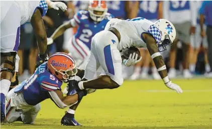  ?? JOHN RAOUX/AP ?? Florida linebacker Ventrell Miller trips up Kentucky running back Kavosiey Smoke before having to leave the game with a foot injury.