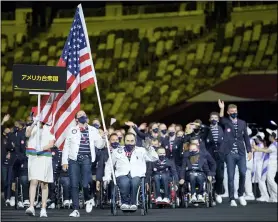  ?? JOEL MARKLUND FOR OIS VIA AP ?? In this photo provided by the Olympic Informatio­n Service, United States Paralympic team athletes Melissa Stockwell and Charles Aoki lead the team during the athletes parade at the opening ceremonies for the Tokyo 2020Paraly­mpic Games in Tokyo, Japan, Tuesday, Aug. 24, 2021.