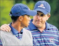  ?? AP PHOTO ?? U.S. team player Phil Mickelson puts his arm around partner Tiger Woods after they lost to Europeans Darren Clarke and Lee Westwood on the final hole of their foursome’s match at the 35th Ryder Cup in 2004.