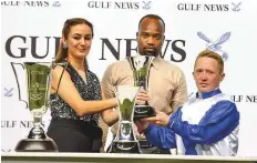  ?? Ahmed Ramzan/Gulf News ?? Mehak Taneja, Relationsh­ip Manager at Gulf News, hands over the trophy to jockey Sam Hitchcott after ES Ajeeb won the Bani Yas yesterday.