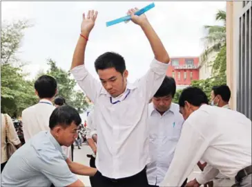  ?? PHA LINA ?? A student is searched for contraband by officials before entering a national exam in 2014.