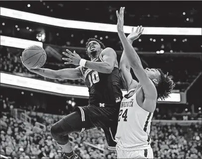  ?? [ALEX BRANDON/THE ASSOCIATED PRESS] ?? Michigan guard Derrick Walton Jr. shoots past Minnesota forward Eric Curry during the second half in a Big Ten tournament semifinal game Saturday in Washington. Michigan won 84-77.