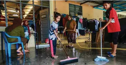  ?? ?? Penduduk melakukan kerja pembersiha­n selepas banjir mulai surut ketika tinjauan di Rumah Mampu Milik (RMM) Teluk Kalong, semalam.