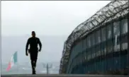  ?? GREGORY BULL — THE ASSOCIATED PRESS FILE ?? Border Patrol agent Eduardo Olmos walks near the secondary fence separating Tijuana, Mexico, background, and San Diego in San Diego.