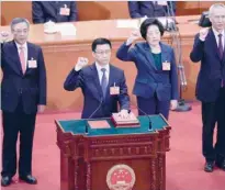  ?? — AFP ?? Newly elected Vice Premiers Hu Chunhua (L), Sun Chunlan (2nd R) and Liu He (R), led by Han Zheng (2nd L), take an oath after being elected on Monday.