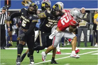  ?? RICHARD W. RODRIGUEZ / AP ?? Ohio State running back Treveyon Henderson tries to get away from two Missouri defensive linemen in the Buckeyes’ Cotton Bowl loss to Missouri in December. Henderson returns to team with newcomer Quinshon Judkins to form what could be the nation’s best tandem at the position.