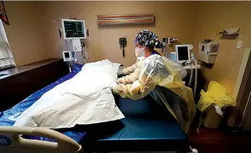  ?? The Associated Press ?? n Medical staff move COVID-19 patient who died onto a gurney to hand off to a funeral home van on Aug. 18 at the Willis-Knighton Medical Center in Shreveport, La.