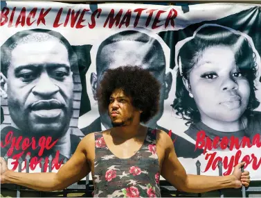  ?? The Associated Press ?? ■ Actor Steven Thompson poses for a picture Friday next to a poster of George Floyd in Los Angeles. Thompson is choosing not to watch the televised trial of Derek Chauvin, the white police officer charged in the death of George Floyd, which has provoked strong emotions among many Black men and women, all tinged with an underlying dread that it could yield yet another devastatin­g disappoint­ment, even though he feels there is a strong case against him.