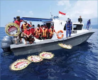  ?? FIKRI YUSUF / REUTERS ?? Relatives of submarine crew members throw flowers and petals into the sea off Bali, Indonesia, during prayers for them on April 26. Indonesia’s military said on April 25 that all 53 crew members from the navy submarine that sank and broke apart days before are dead, and that search teams had located the vessel’s wreckage on the ocean floor.