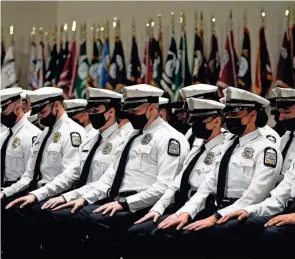  ?? ADAM CAIRNS/COLUMBUS DISPATCH ?? Recruits sit in prayer during the Columbus Division of Police graduation ceremony for its 136th recruit class at the Columbus Police Academy on Jan. 14.