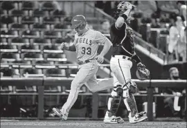  ?? Ralph Freso Getty Images ?? MAX STASSI of the Angels scores the go-ahead run behind Arizona catcher Stephen Vogt following a double by José Iglesias during the ninth inning.