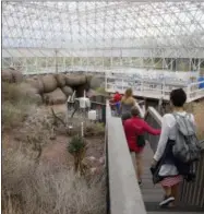  ?? AP PHOTO/ROSS D. FRANKLIN ?? In this Friday, July 31, 2015, photo, tourists walk through the enclosed coastal fog desert ecosystem of the Biosphere 2in Oracle, Ariz. Biosphere 2lives on as a successful research site 25years after eight people emerged from the New Age-style experiment in the Arizona desert.