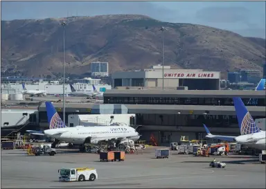  ?? (AP/Eric Risberg) ?? United Airlines planes are seen parked at San Francisco Internatio­nal Airport with a maintenanc­e hangar in the background on in July, in San Francisco.