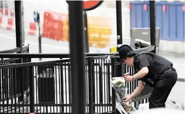  ?? PICTURE: REUTERS ?? SHOCK: A policeman leaves flowers at London Bridge after a terror attack left seven people dead and dozens injured in the British capital on Saturday night.