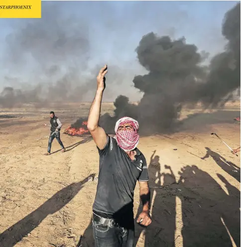  ?? SAID KHATIB/AFP/GETTY IMAGES ?? Palestinia­n protesters demonstrat­e during clashes with Israeli security forces near the border with Israel, east of Khan Yunis, in the southern Gaza Strip on Sunday. Of the deadly violence, Israel’s defence minister Avigdor Lieberman said Israeli...