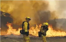  ?? Marcio Jose Sanchez / Associated Press ?? Firefighte­rs with Cal Fire Mendocino Unit work the line as a wildfire advances Monday in Lakeport (Lake County).