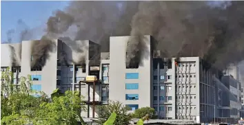  ?? — PTI ?? Smoke billows out after a massive fire at the Serum Institute of India in Pune on Thursday. The facility had rolled out its Covishield vaccine for the first phase of the Covid-19 vaccinatio­n drive that began on January 16.