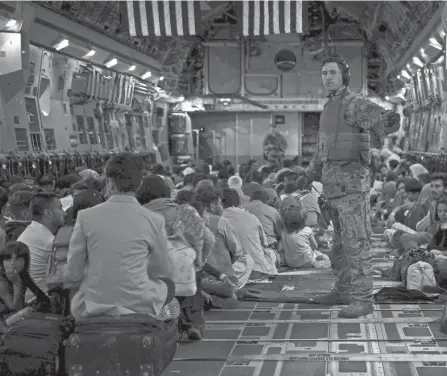  ?? SENIOR AIRMAN TAYLOR CRUL/U.S. AIR FORCE VIA AP ?? A U.S. Air Force loadmaster guides evacuees aboard a U.S. Air Force C-17 Globemaste­r III aircraft in Kabul, Afghanista­n on Saturday. The U.S. has so far ferried thousands of people to safety.