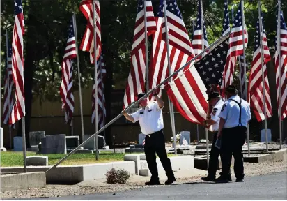  ?? PHOTOS BY PETER ARMSTRONG ?? Veterans install an American flag before the Memorial Day Observance at the Russian River Cemetery in Ukiah on Monday.