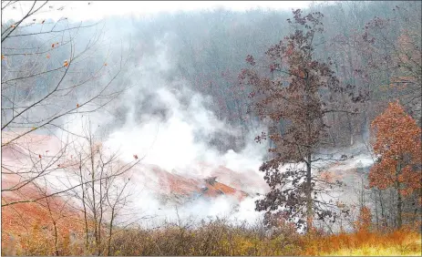  ?? David Gottschalk/NWA Democrat-Gazette ?? Smoke rises Friday, Dec. 14, from an undergroun­d fire at the former "stump dump" site on Trafalgar Road in Bella Vista. The site was once a Bella Vista Property Owners Associatio­n "stump dump" at which residents of the city could dump yard waste.