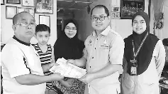  ??  ?? Dundang (second right) presents the cheque to Sapiee, witnessed by Rahani (centre) and Asmawati (right).