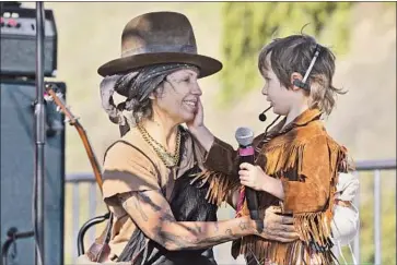  ?? Francine Orr Los Angeles Times ?? SINGER LINDA PERRY performs with her son Saturday outside Dodger Stadium at a two-day Rock ’N’ Relief concert series featuring dozens of musicians helping to raise money for mobile COVID vaccinatio­n units.