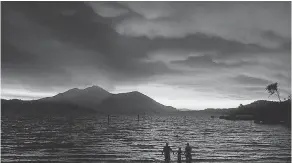  ?? AP ?? Evacuees from Lucerne, Calif., watch the sunset through the smoke at Austin Park Beach in Clearlake. Mount Konocti is in the background.