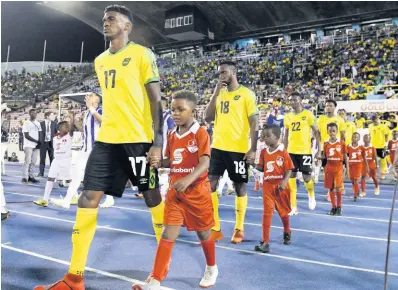  ?? FILE PHOTOS ?? Damion Lowe (foreground) and other members of the Reggae Boyz team making their way on to the field ahead of Jamaica’s match against Honduras in the Concacaf Gold Cup at the National Stadium in 2019.