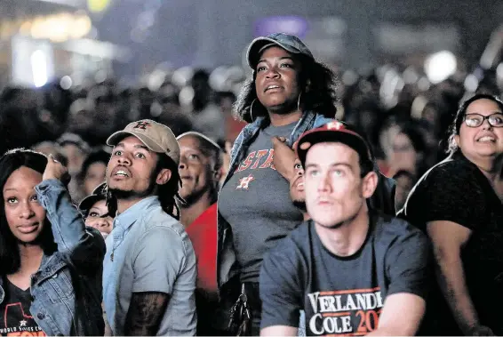  ?? Elizabeth Conley / Staff photograph­er ?? The faces of fans watching at a parking lot near Minute Maid Park tell the story of Game 6 of the World Series as the Astros fall to the Nationals, evening the series 3-3.