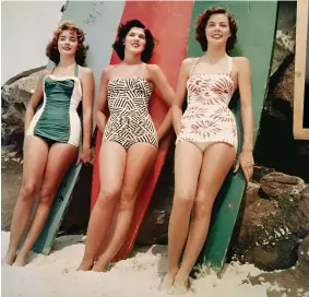  ??  ?? Miss Pacific beauty
pageant finalists Mary Clifton Smith, Pamela Jansen and Judy Worrad pose in front of colourcoor­dinated toothpick surfboards on Bondi Beach, Sydney, sporting the latest one-piece bathing suit fashions, 1952.