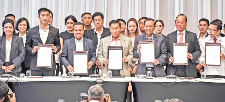  ??  ?? Leaders of Thai political parties show signed documents during a press conference in Bangkok. A coalition of seven parties vowed to push back on military-backed parties but remain far from forming a majority government as Thai politics remain deadlocked days after its first election since a coup.— AFP photo