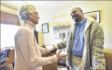  ?? HYOSUB SHIN / HSHIN@AJC.COM ?? Larry Johnson (right), a new foster father of three brothers, and Kathy Colbenson, president and CEO of CHRIS 180, talk at her office. Georgia has seen a dramatic increase in foster children, going from 7,600 in 2013 to 13,266 today.