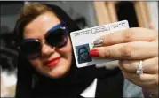 ?? SEAN GALLUP / GETTY IMAGES ?? Nada Edlibi holds up her driver’s license Sunday — the first day she is legally allowed to drive in Saudi Arabia. Saudi Arabia lifted a ban on women driving that had been in place since 1957.