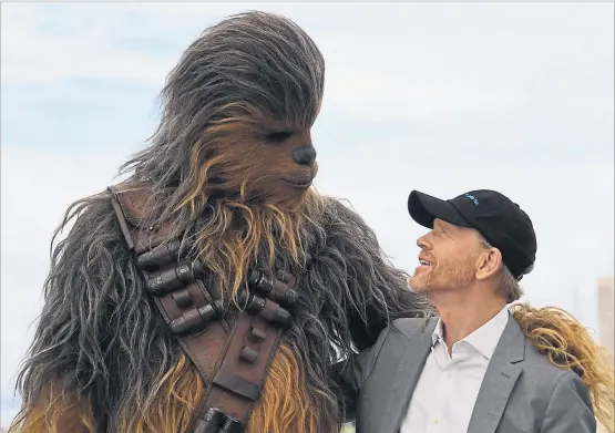  ?? [ AFP ] ?? „Ich hatte viel Spielraum für Experiment­e“, sagt Ron Howard (hier neben „Star Wars“-Figur Chewbacca), der die Regie für den neuen Film kurzfristi­g übernahm.