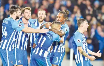  ??  ?? Brighton’s Spanish midfielder Jose Izquierdo (C) is mobbed by celebratin­g team-mates after he scored a second equalising goal for 2-2 during the English Premier League football match between Brighton and Hove Albion and Stoke City at the American Express Community Stadium in Brighton, southern England on November 20, 2017. - AFP photo