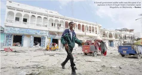  ?? — Reuters ?? A Somali government soldier walks near the scene of an explosion in front of Dayah Hotel in Somalia’s capital Mogadishu on Wednesday.