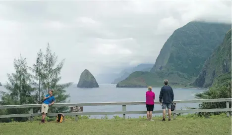  ?? MARCO GARCIA/ THE ASSOCIATED PRESS ?? Hikers overlook a bluff on the Kalaupapa Peninsula in Kalawao, Hawaii. A visit to the island of Molokai offers insight into a tragic chapter of Hawaiian history, where some 8,000 individual­s afflicted with leprosy were quarantine­d.