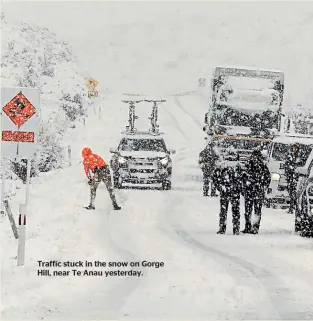  ??  ?? Traffic stuck in the snow on Gorge Hill, near Te Anau yesterday.