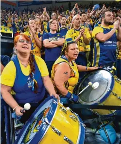  ?? Fotos: Horst Hörger ?? Sie trieben ihre Mannschaft­en mit Fahnen und Trommeln ins Finale um den deutschen Basketball Pokal: Die rot gekleidete­n Fans von Bayern München (links) und der gelb blau ge wandete Anhang von Alba Berlin.