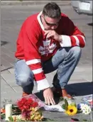  ?? The Canadian Press ?? Fan Richard Noble lays flowers on The Tragically Hip commemorat­ive plaque in Kingston, Ont., on Wednesday.