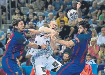  ?? FOTO: PERE PUNTÍ ?? Viran Morros y Raúl Entrerríos tratan de frenar a Lukas Nilsson en un Barça-Kiel de la temporada pasada