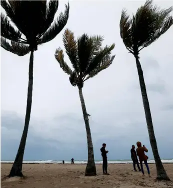  ?? ASSOCIATED PRESS PHOTOS ?? People on Saturday watch churning waves along Hollywood Beach, Fla.