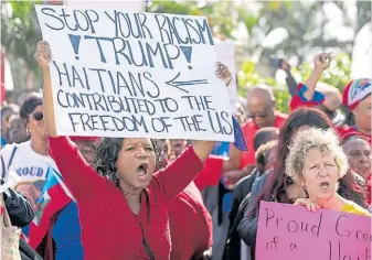  ?? AP ?? Protesta. Inmigrante­s haitianos en Florida, contra las frases racistas de Donald Trump.