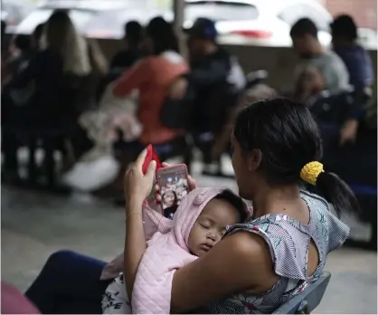  ?? FOTO: TT-AP/LEO CORREA ?? En mor vaggar sitt barn i väntan på vaccinerin­g i brasilians­ka Rio de Janeiro i augusti i år.■