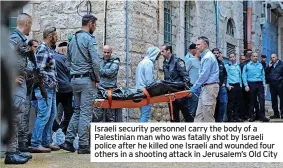  ?? ?? Israeli security personnel carry the body of a Palestinia­n man who was fatally shot by Israeli police after he killed one Israeli and wounded four others in a shooting attack in Jerusalem’s Old City