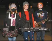  ?? Mona Weatherly ?? With musical instrument­s draped in lights, members of the Broken Bow Middle School Band are ready to play. From left, all eight graders, are: Emma Olson, daughter of Pete and Kyla Olson; Addisen Loughran, daughter of Matt and Misti Loughran; and Michael Forster, son of Helen and Adam Forester.