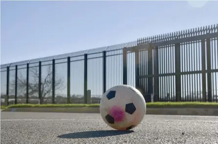  ?? — AFP ?? A soccer ball is seen on a street in front of metal wall border between US and Mexico in Eagle Pass, US.