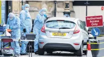  ?? PHOTO: REUTERS ?? Gathering evidence . . . Forensic investigat­ors work at the site where a car crashed outside the Houses of Parliament in Westminste­r, London, on Tuesday.
